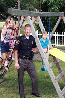 deputy with children on a playset